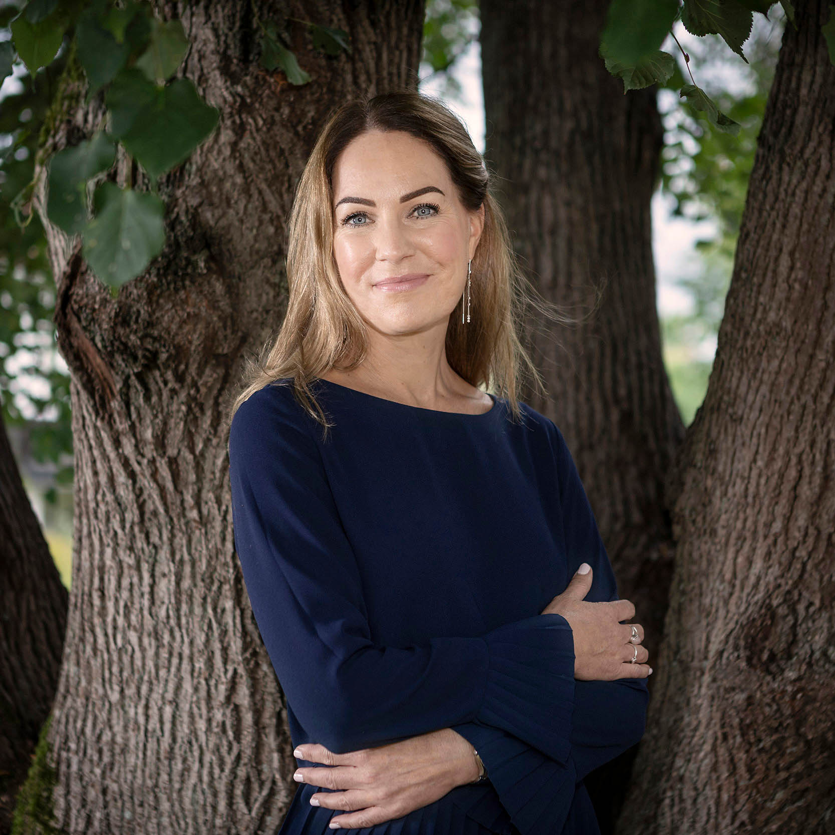 Kvinna som står vid ett träd